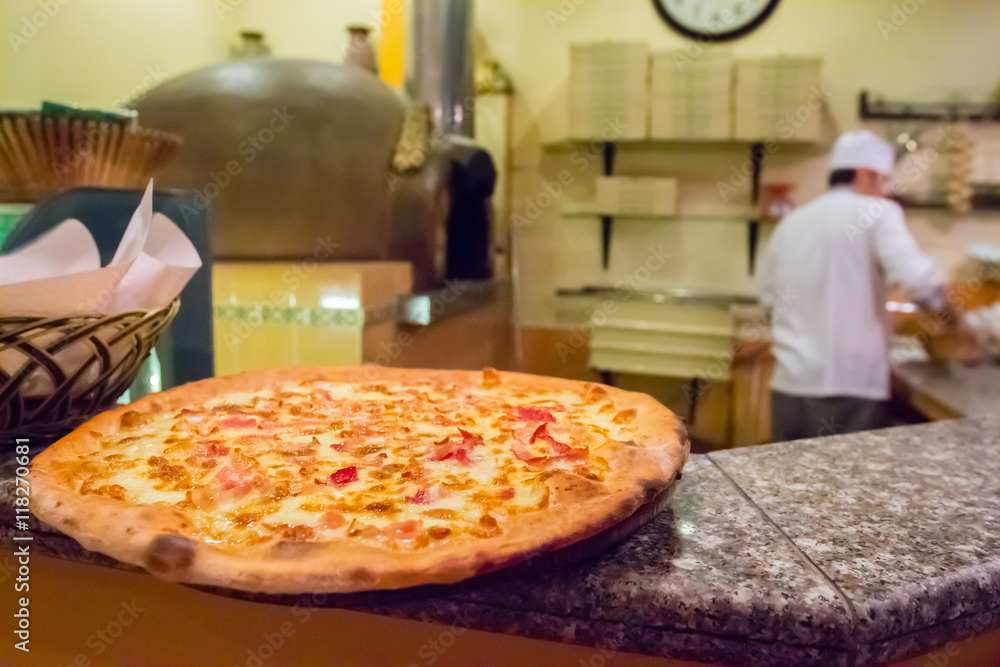 Pizza on the shelf inside italian restaurant with blurry backgro