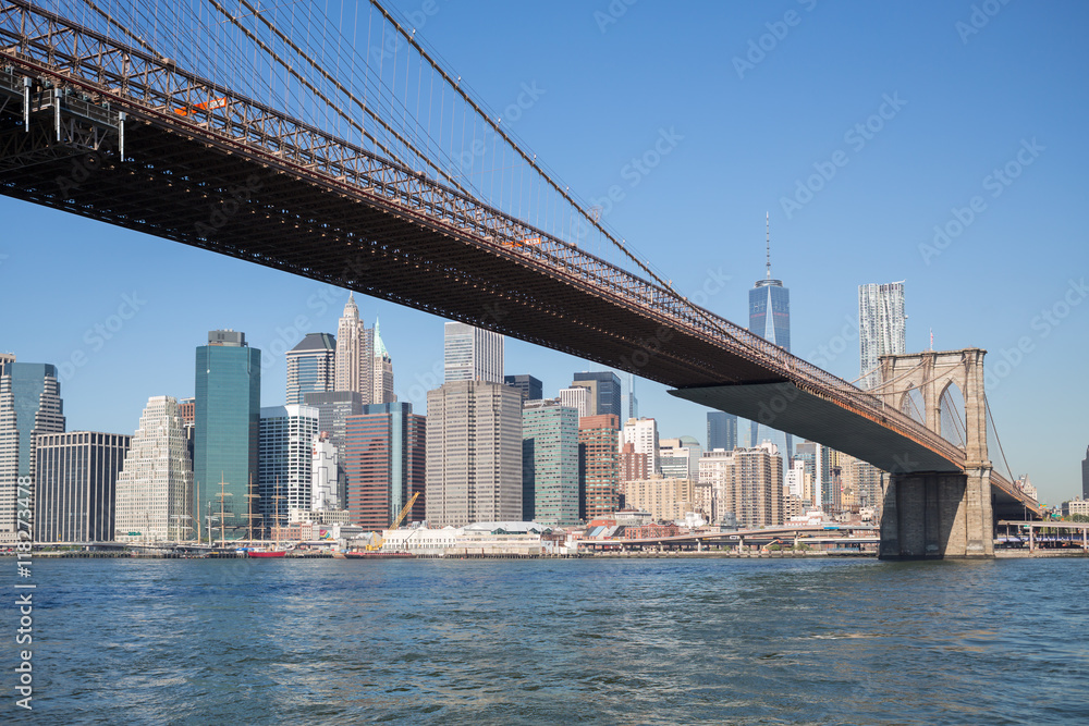 Cityscape of Brooklyn Bridge across East River at autumn day.