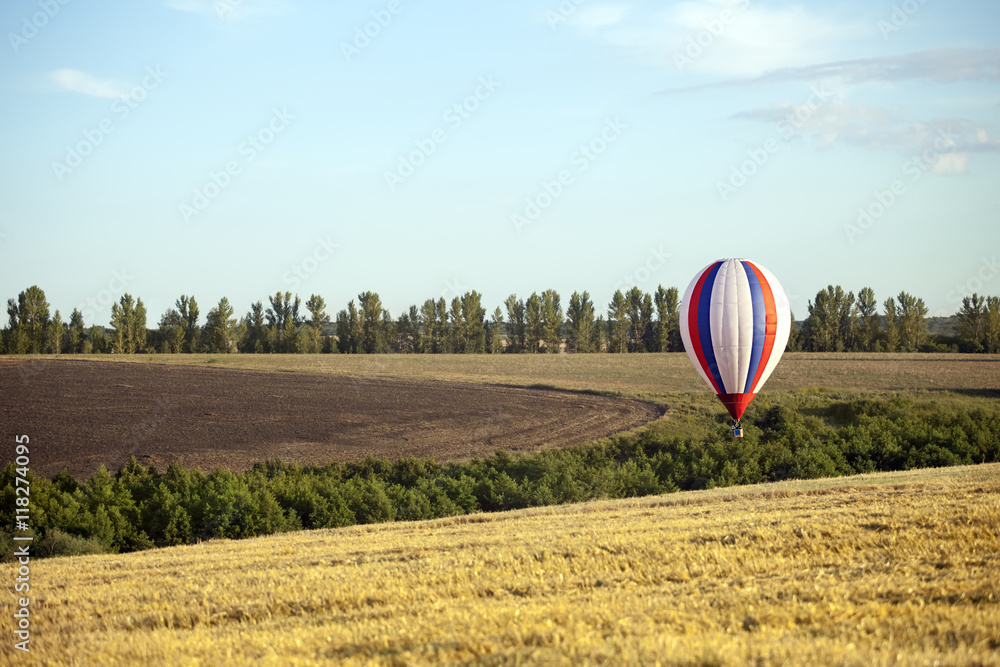 Obraz premium Balloons start fly on fields, hills in summer