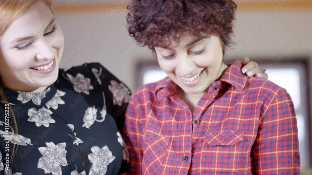 Affectionate gay female couple at home, 1 woman preparing a meal in kitchen Affectionate gay female couple at home, 1 woman preparing a meal in kitchen
