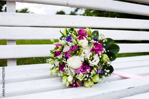 Beautiful bridal bouquet of flowers on wooden bench 