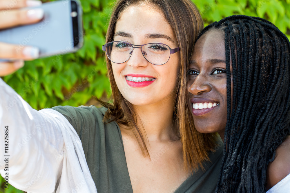 Teen diverse girlfriends taking self portrait. Teen diverse girlfriends taking self portrait.