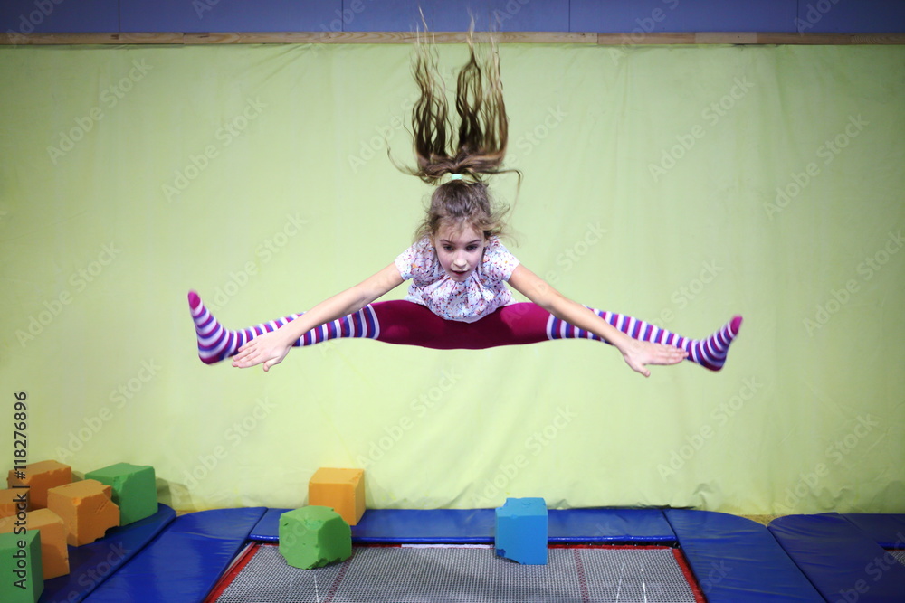 Girl is jumping high in striped tights on the big trampoline. Stock Photo | Adobe Stock Girl is jumping high in striped tights on the big trampoline. Stock Photo | Adobe Stock