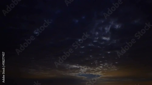 Dark clouds are transforming and moving across the night sky and moon. Time-lapse, UHD - 4K