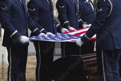 Soldiers folding flag at military funeral