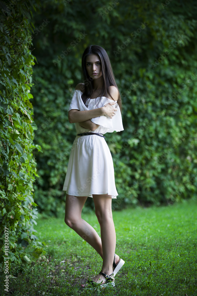 Full length portrait of a beautiful young caucasian woman in white dress with open shoulders, clean skin, long hair and casual makeup Full length portrait of a beautiful young caucasian woman in white dress with open shoulders, clean skin, long hair and casual makeup
