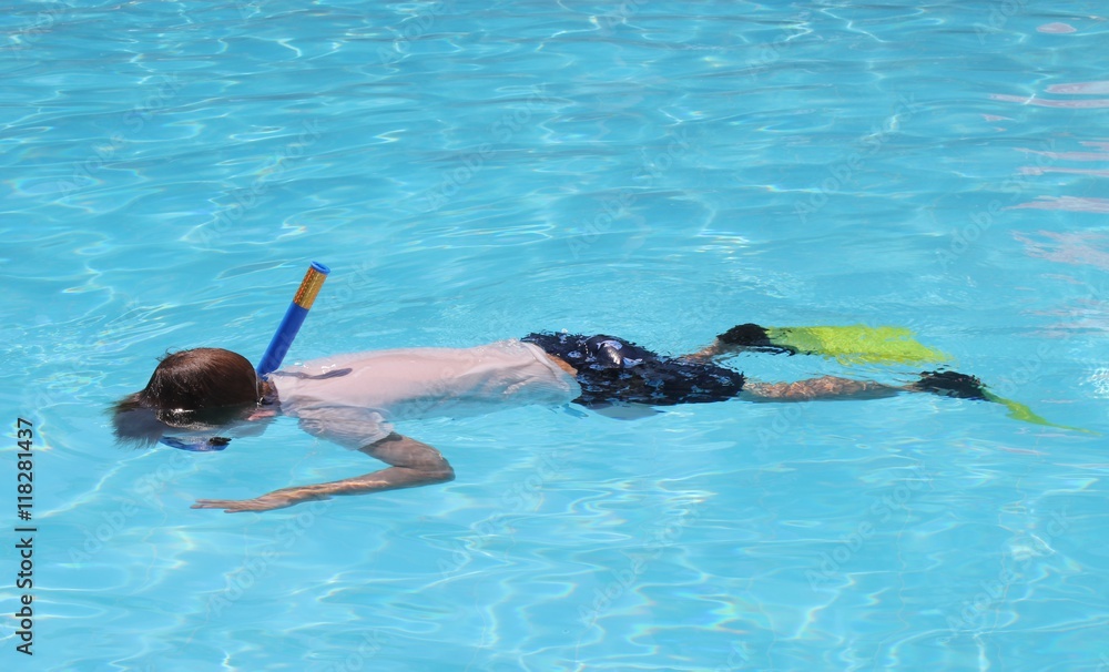 A young boy snorkeling in a swimming pool while on vacation, 2016