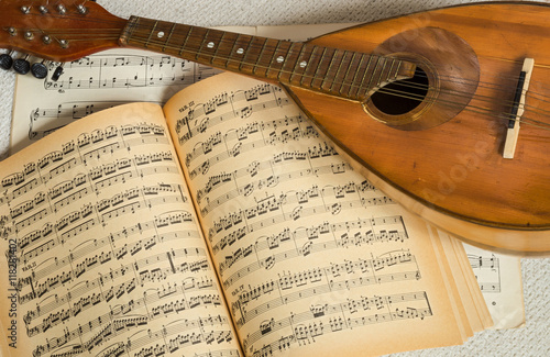 Old mandolin with music notes in the background.