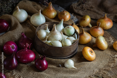 Yellow, red and white onions on a wooden surface