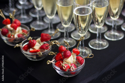 Canapes of cheese and strawberries with champagne photo
