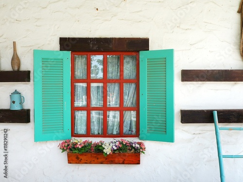 Картината върху платно Window box on the white wall with colorful geranium