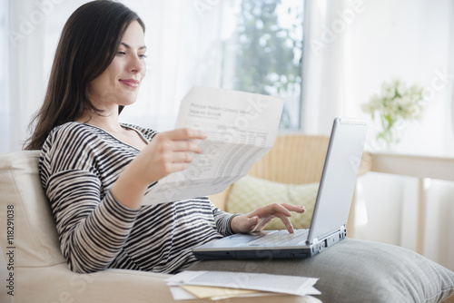 Caucasian woman paying bills using laptop