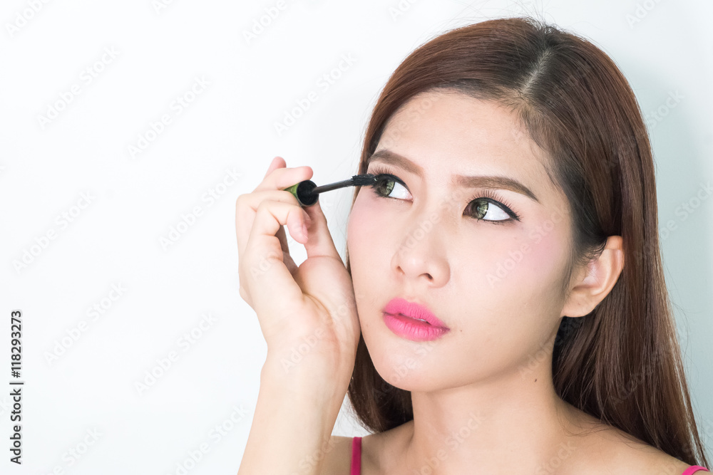 Makeup woman putting mascara eye make up on eyes. Asian fresh fa Makeup woman putting mascara eye make up on eyes. Asian fresh fa