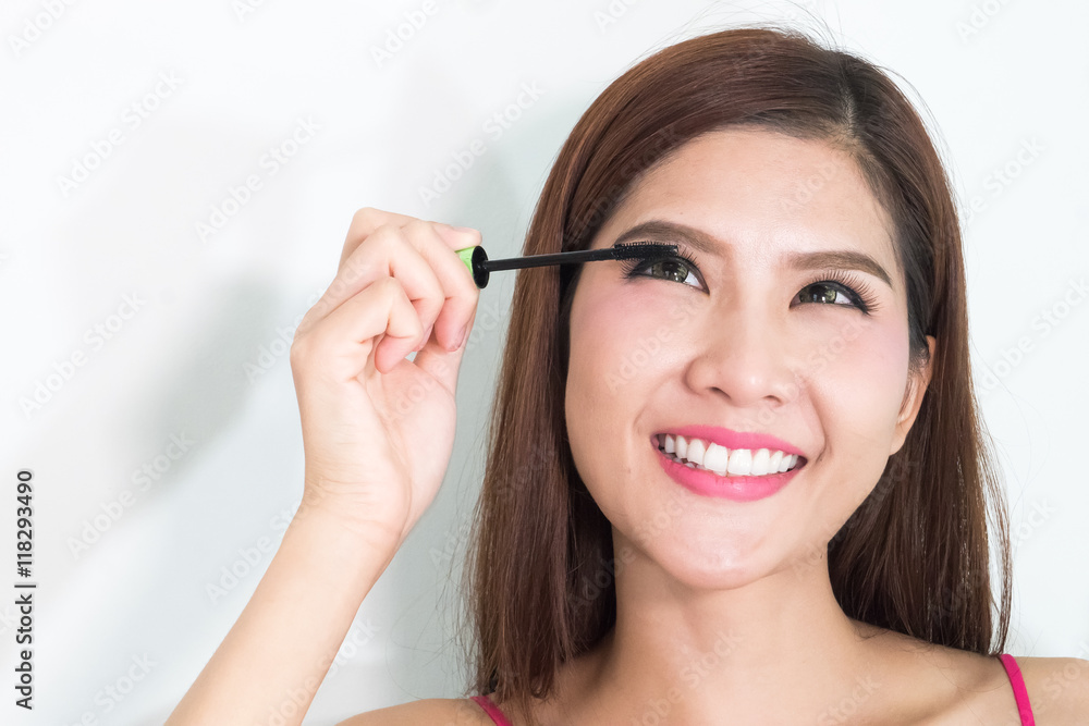 Makeup woman putting mascara eye make up on eyes. Asian fresh fa Makeup woman putting mascara eye make up on eyes. Asian fresh fa