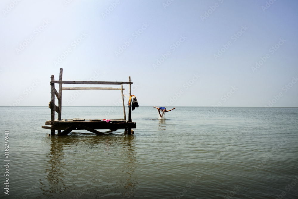 Person jumping from pier into ocean Person jumping from pier into ocean