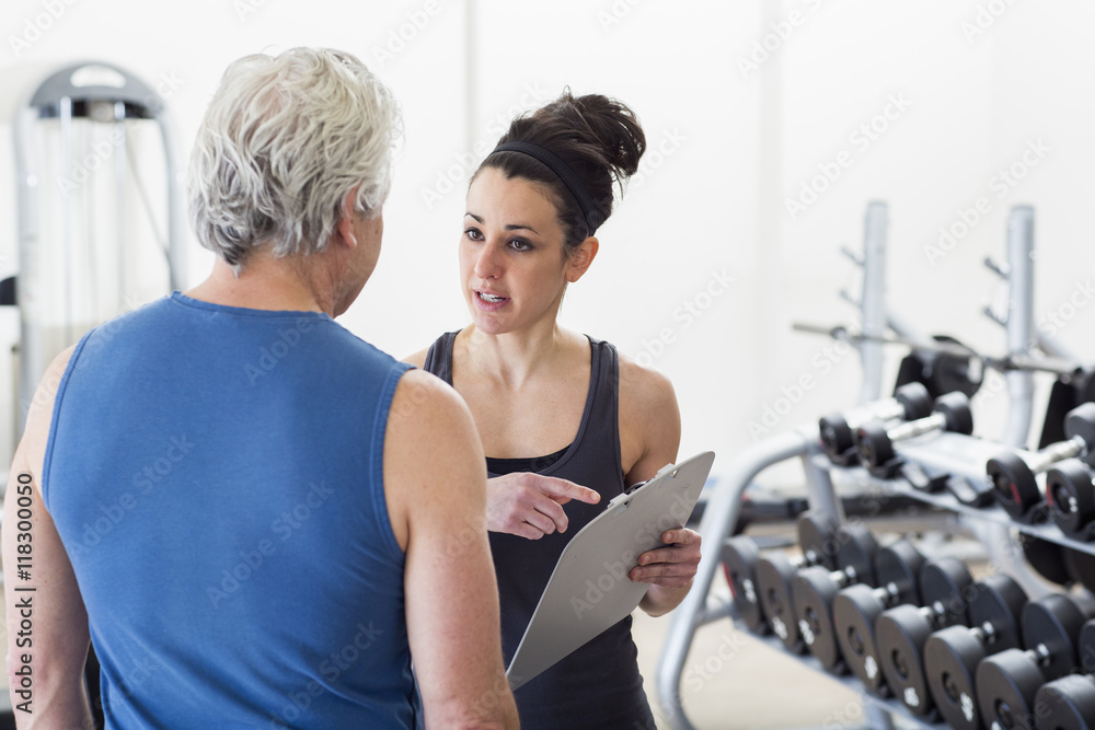 © Marc Romanelli/Blend Images - Older Hispanic man working with trainer in gym