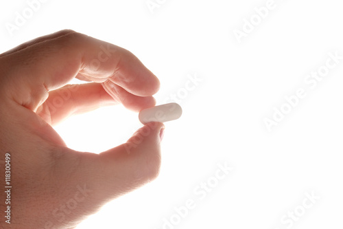 medicinal tablet in hand on the background of bright white light