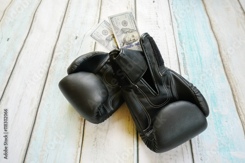 Money with boxing gloves on wooden background © FootageLab