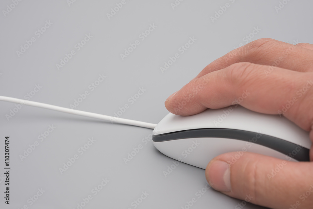 man using a white mouse on a grey background close up