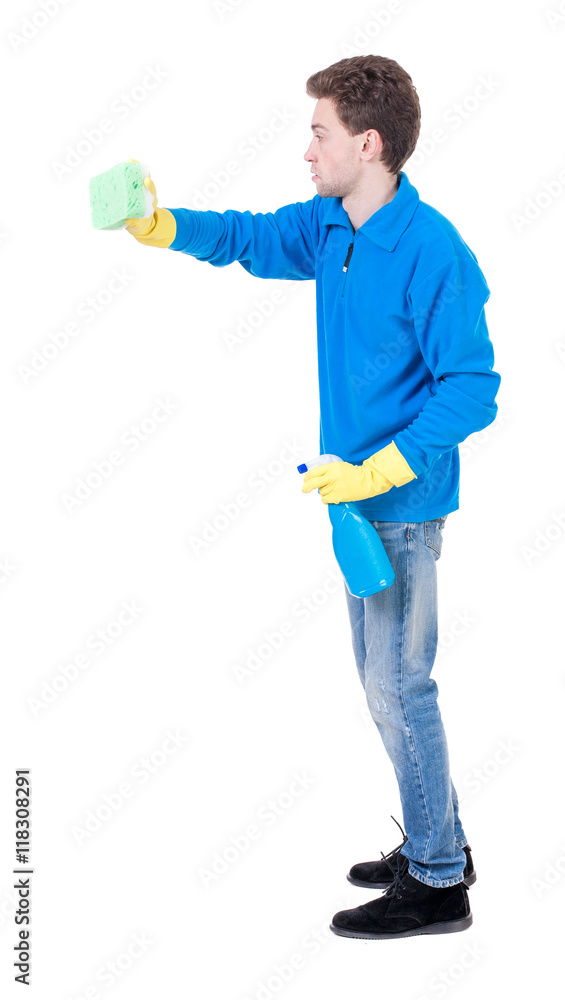 side view of a cleaner man in gloves with sponge and detergent. girl watching. view of person. Isolated over white background. Curly boy in the blue jacket cleans. side view of a cleaner man in gloves with sponge and detergent. girl watching. view of person. Isolated over white background. Curly boy in the blue jacket cleans.