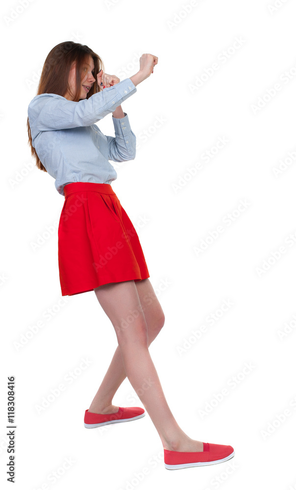 skinny woman funny fights waving his arms and legs. Isolated over white background. Long-haired brunette in red skirt leaned protected from impact. skinny woman funny fights waving his arms and legs. Isolated over white background. Long-haired brunette in red skirt leaned protected from impact.
