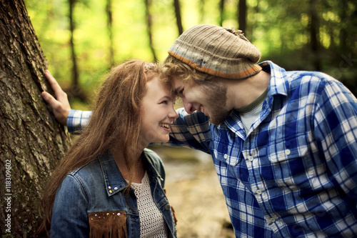 Couple touching foreheads in forest photo