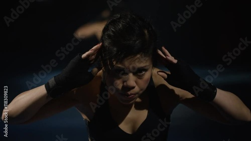  Female MMA fighter doing sit ups in front of mirror at the gym.  photo