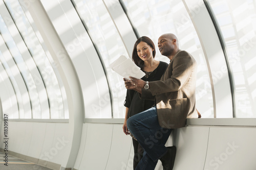 Business people reading paperwork in corridor