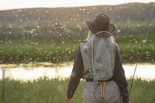 Caucasian woman wearing fishing gear in remote lake
