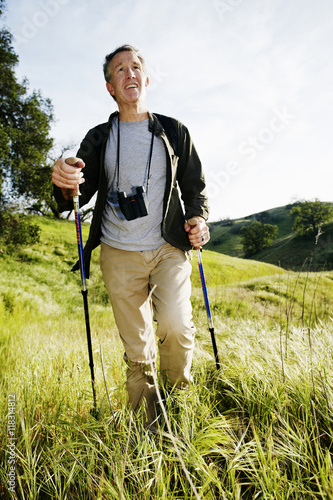 Caucasian man hiking in grass on mountain