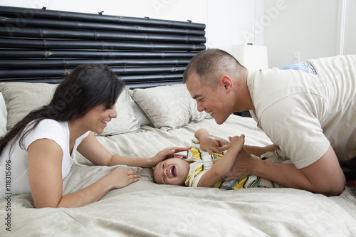 Family playing on bed in bedroom