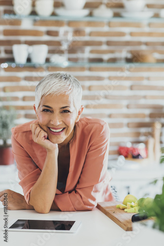 Older Caucasian woman smiling in kitchen photo