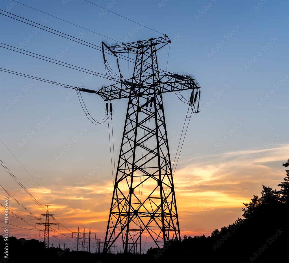 Electric pole connect to the high voltage electric wires on sunset sky background.
