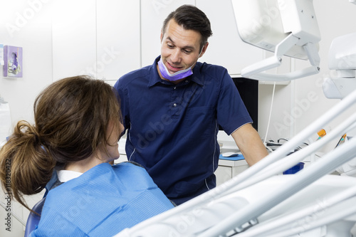 Male Dentist Communicating With Female Patient In Clinic