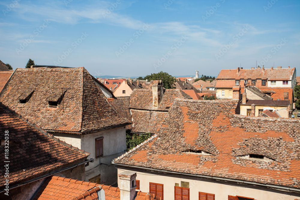 Aerial view of tiled rooftops. A house with attic windows like with smiling eyes