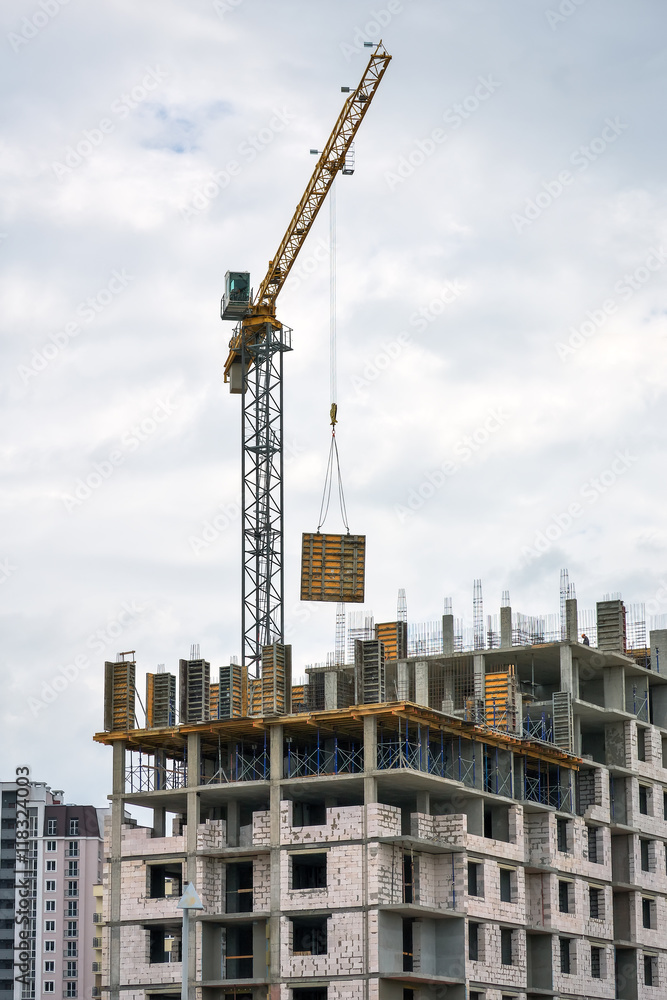 Construction of multi-storey buildings with Crane. Workers work