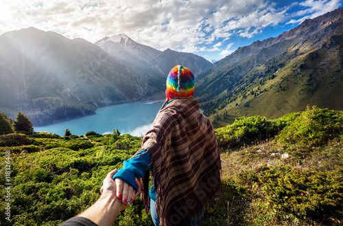 Tourist woman in rainbow hat at the mountains photo