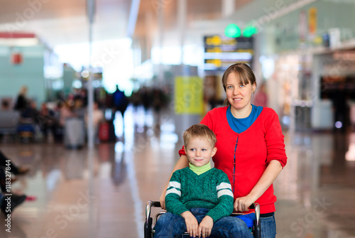 mother and little son on trolley in the airport