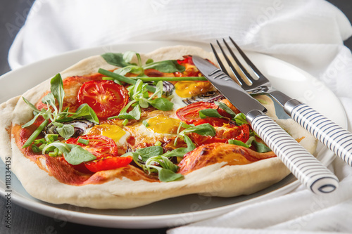 Home Italian pizza with tomato and quail eggs salad