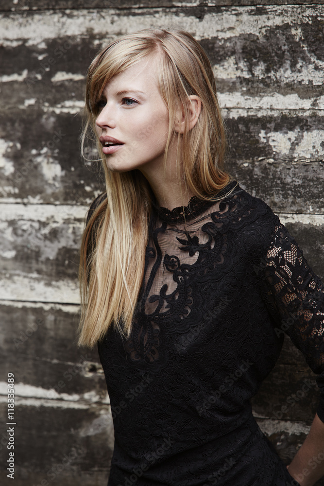 Beautiful blond in lace top against wooden wall Beautiful blond in lace top against wooden wall