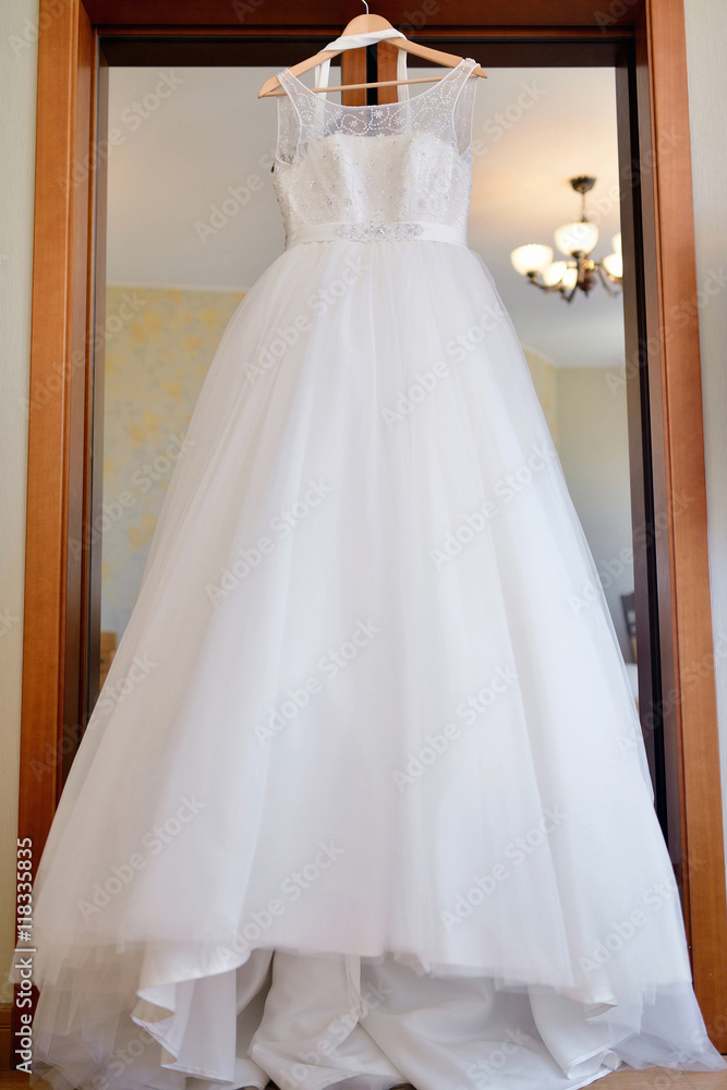 Beautiful white wedding dress for bride indoors. Beauty of bridal gown for marriage. Female lace clothes for celebration Beautiful white wedding dress for bride indoors. Beauty of bridal gown for marriage. Female lace clothes for celebration
