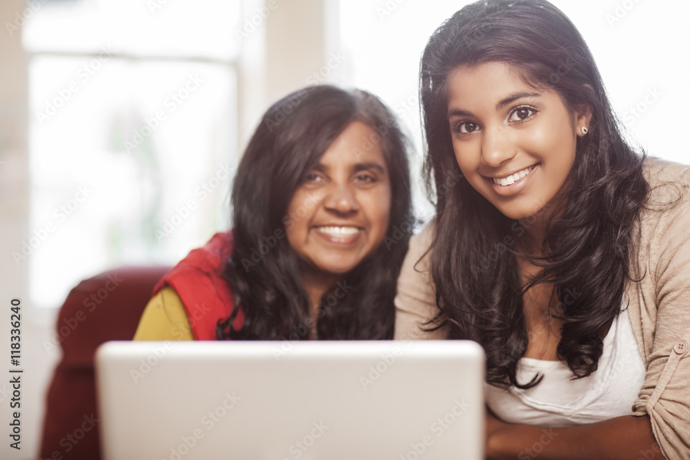 Indian mother and daughter using laptop together Indian mother and daughter using laptop together