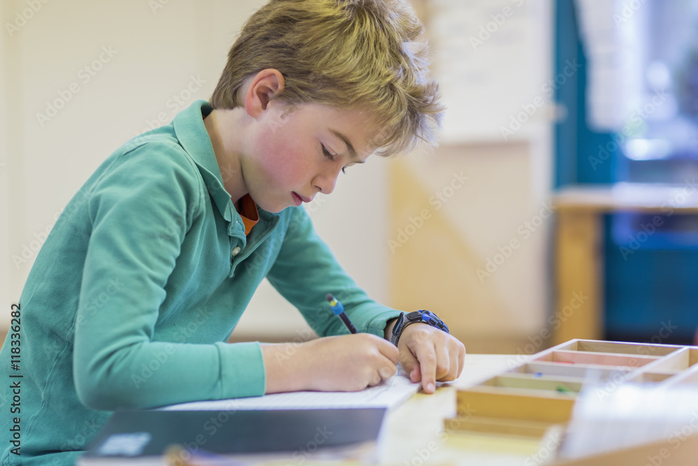 Caucasian boy writing in classroom Caucasian boy writing in classroom