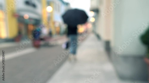 Wallpaper Mural Blurred slim brunette girl with umbrella walking with her purchasings in paper bags along outlet shops. 4K bokeh background video Torontodigital.ca