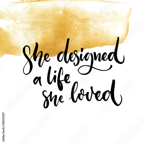 She designed a life she loved. Feminism quote lettering at golden paint stroke texture