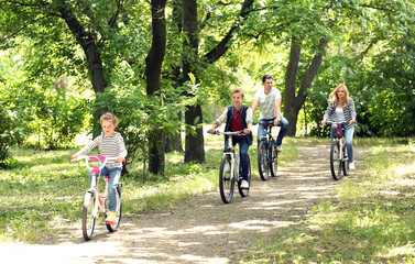 Happy family on bike ride in park