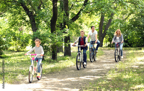 Happy family on bike ride in park