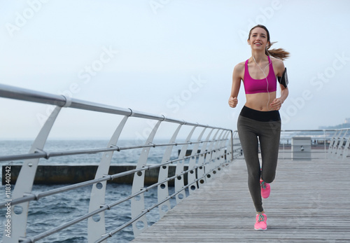 Young woman running on pier