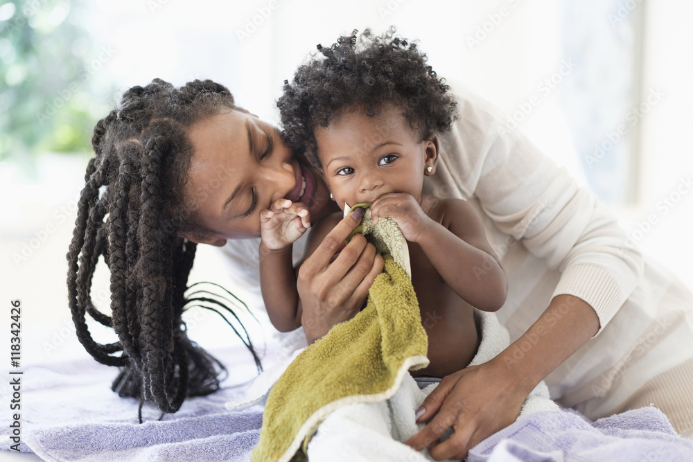 Black woman drying baby daughter with towels Black woman drying baby daughter with towels