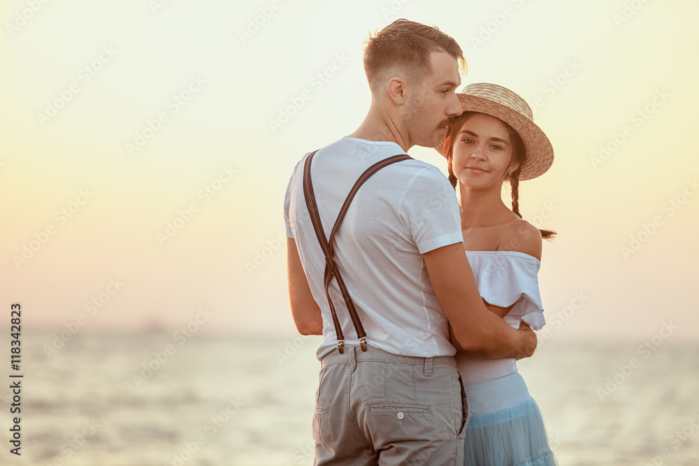 Happy young romantic couple relaxing on the beach and watching the sunset Happy young romantic couple relaxing on the beach and watching the sunset